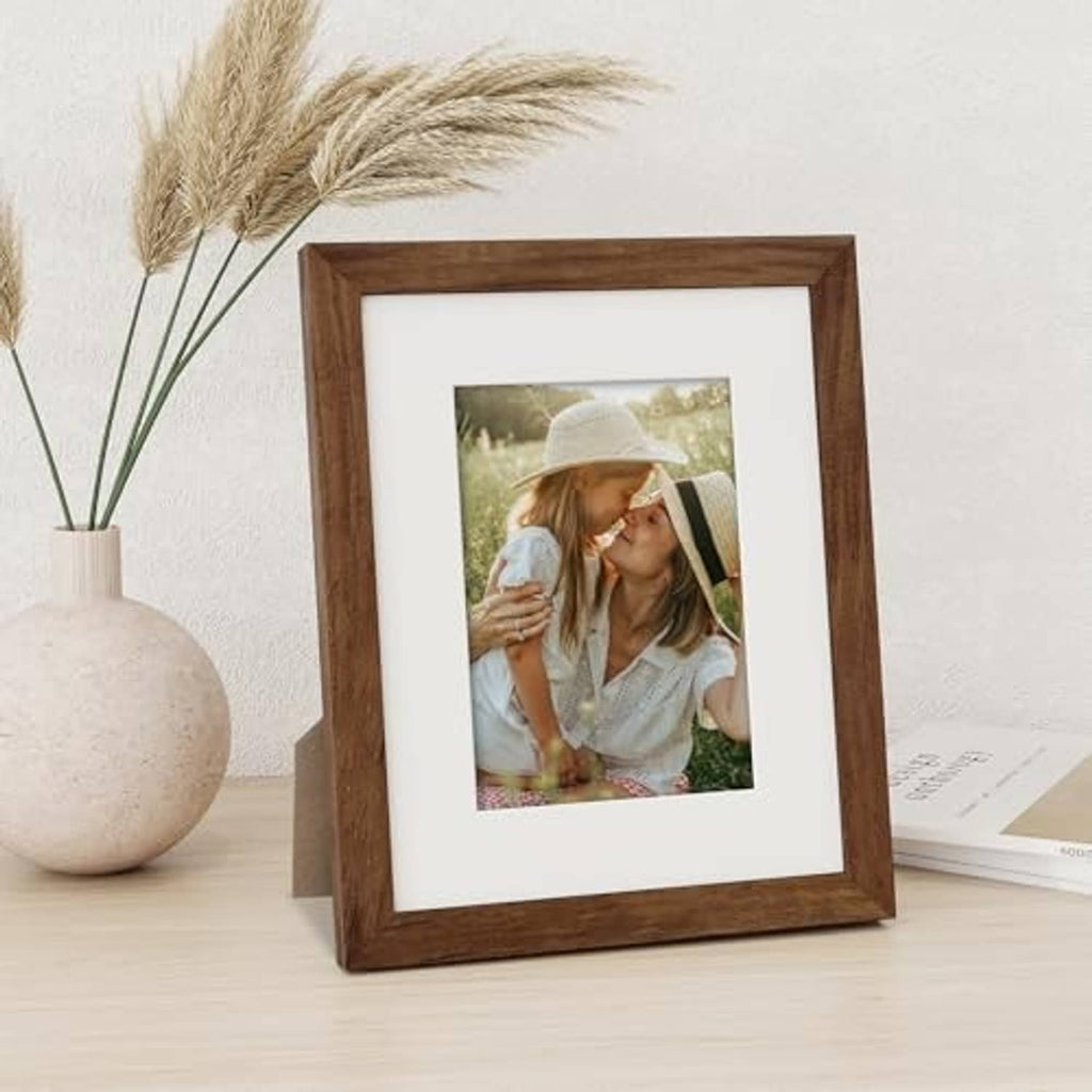 Walnut picture frame with off-white mat holding a vertical outdoor photo.