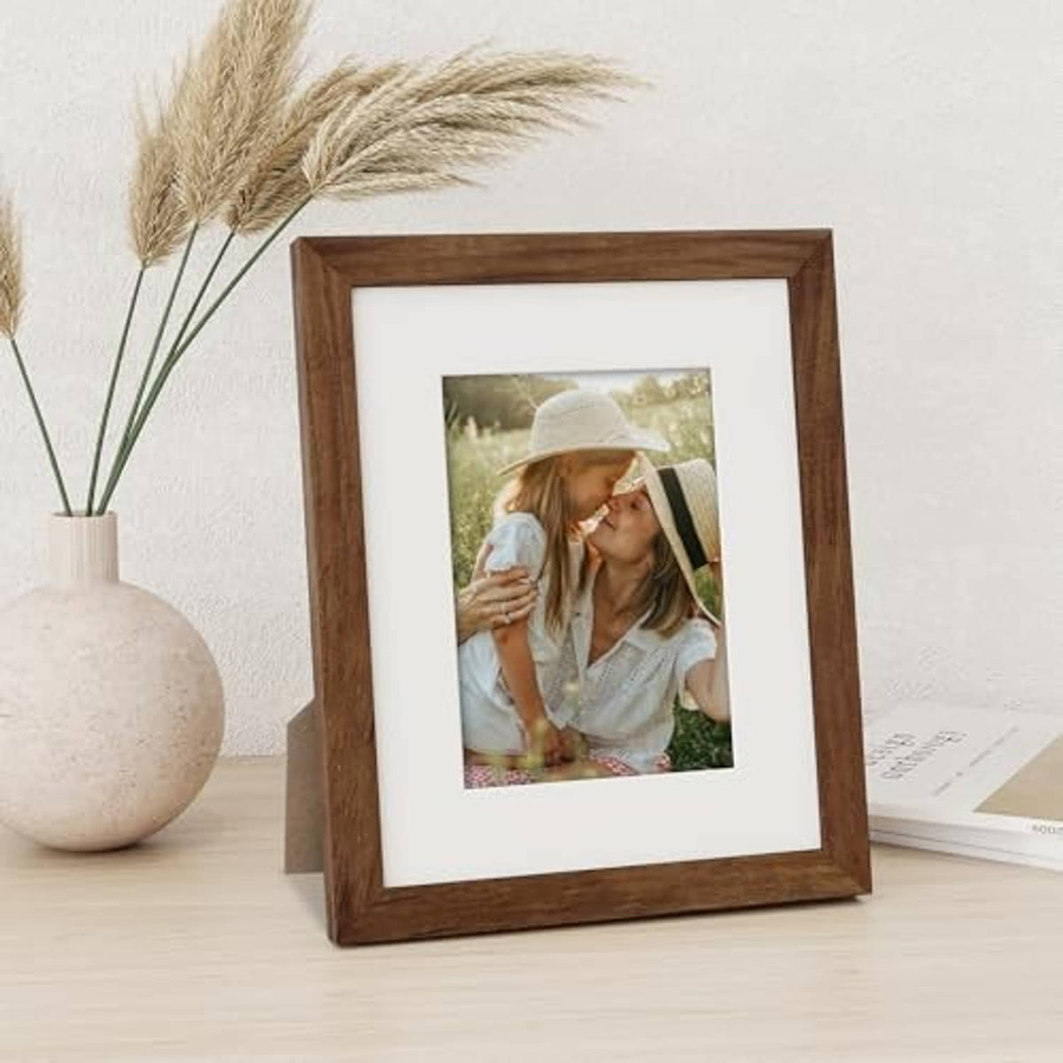 Walnut picture frame with off-white mat holding a vertical outdoor photo.