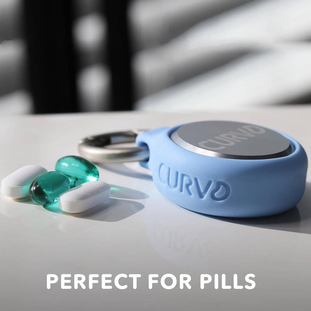 Blue keychain case with silver lid holding small green pills