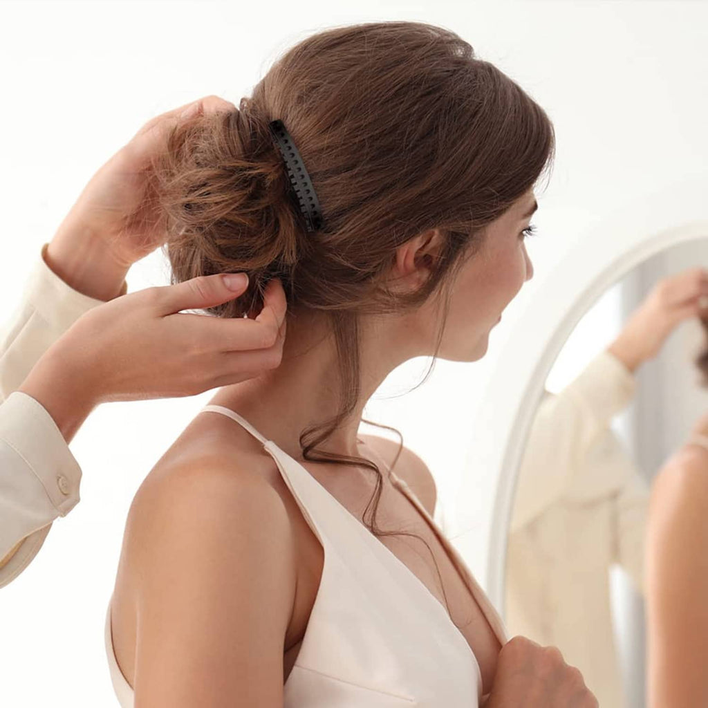 Plastic hair side comb with dark teeth, clipped at the side of a dark bun