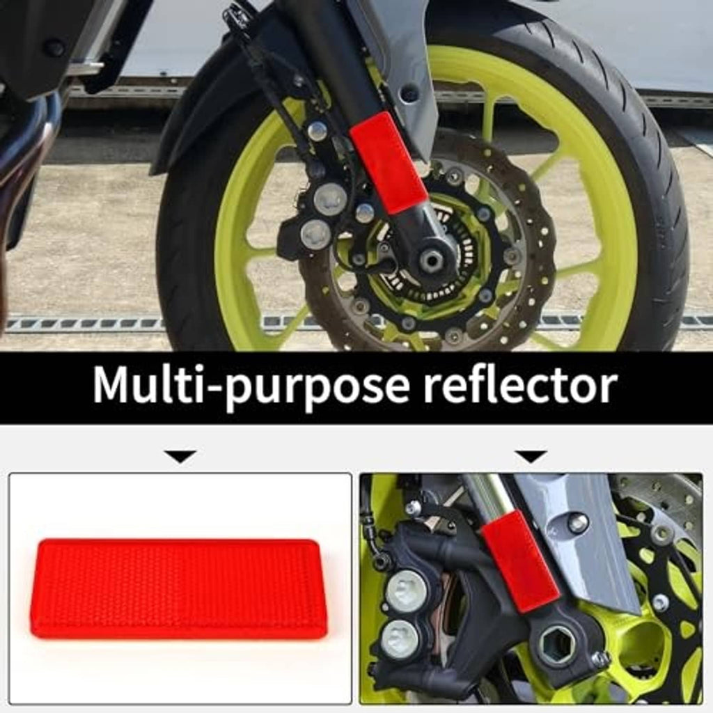 Red rectangular multi-purpose reflector attached near motorcycle wheel, reflective plastic