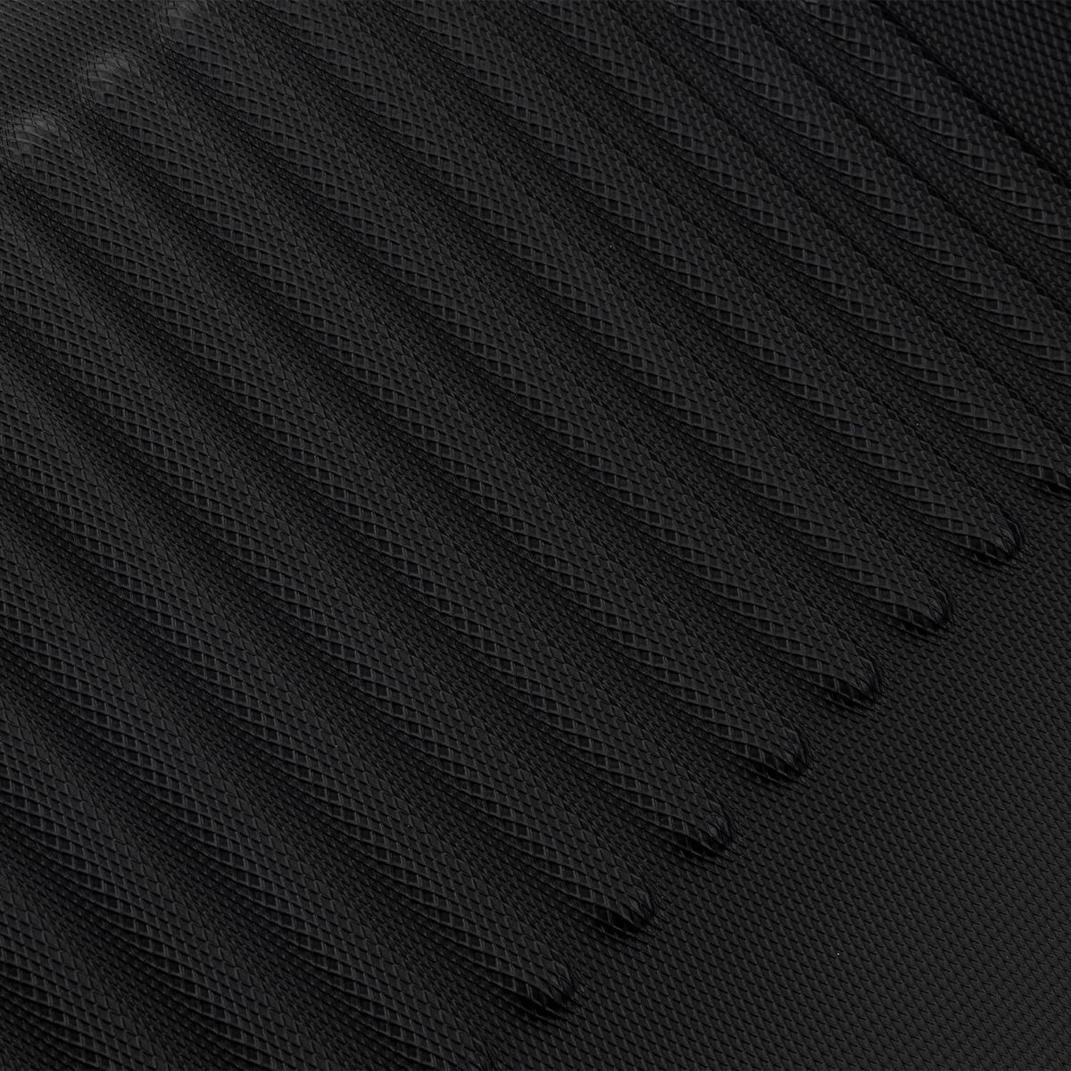 Close-up of black rubber floor mat with raised wave ridges for traction