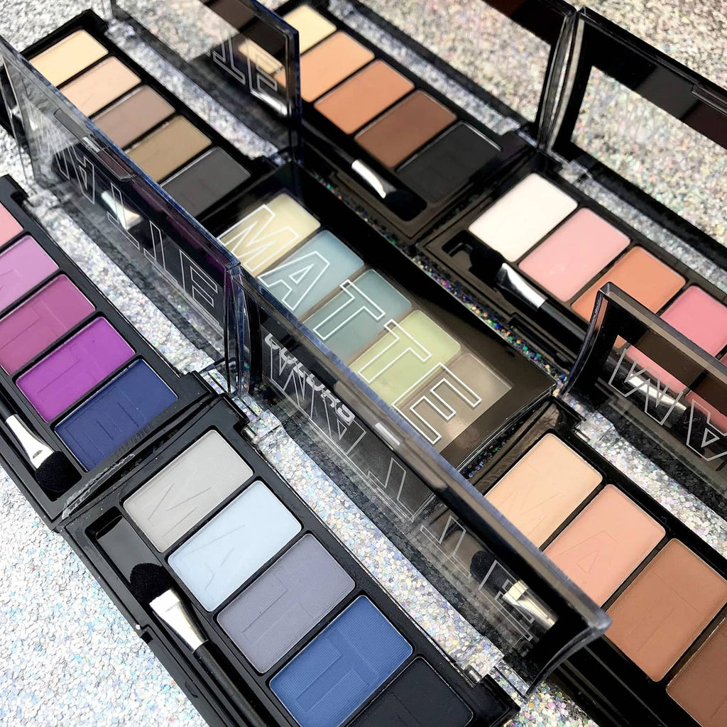 Opened matte eyeshadow palettes with nude, mauve, and neutral pans