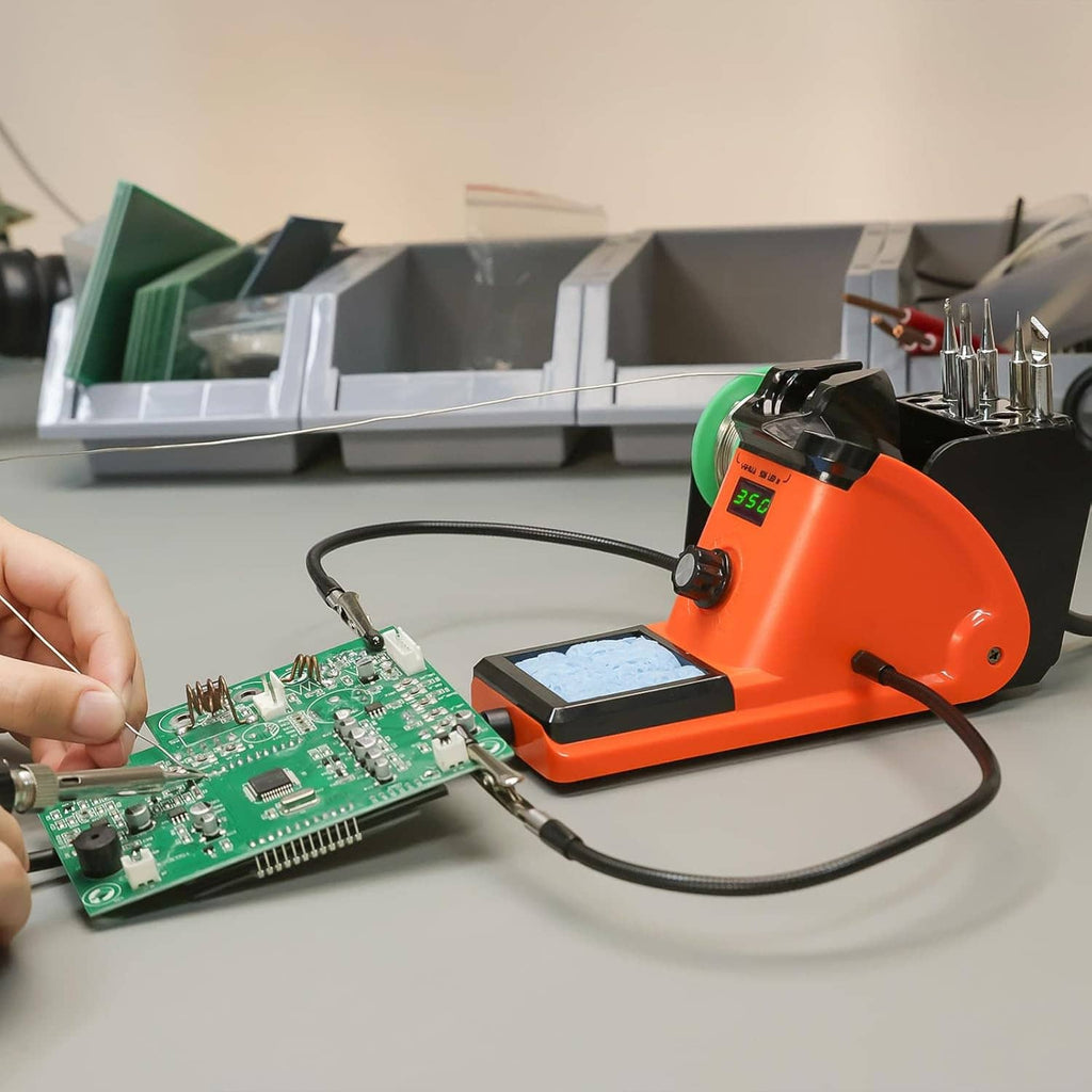 Orange soldering iron station in use, soldering a PCB with iron tip