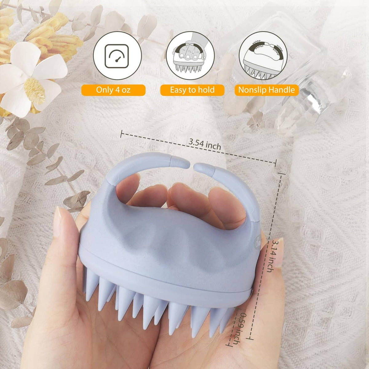 Sky blue scalp massager shampoo brush held in hand, with short silicone bristles