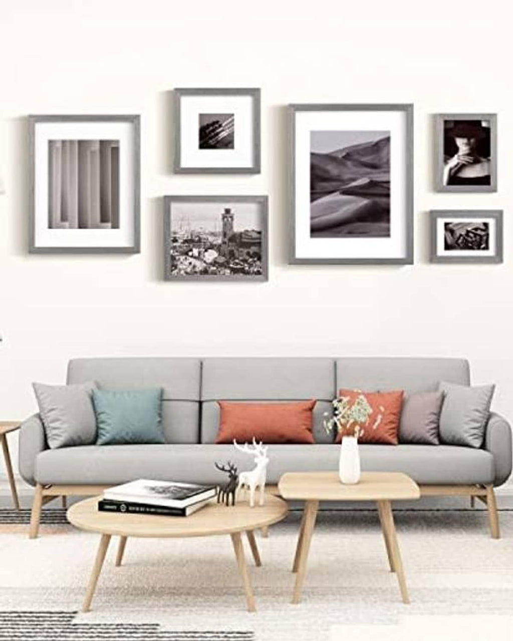 Light grey solid wood picture frames arranged on a wall above a sofa
