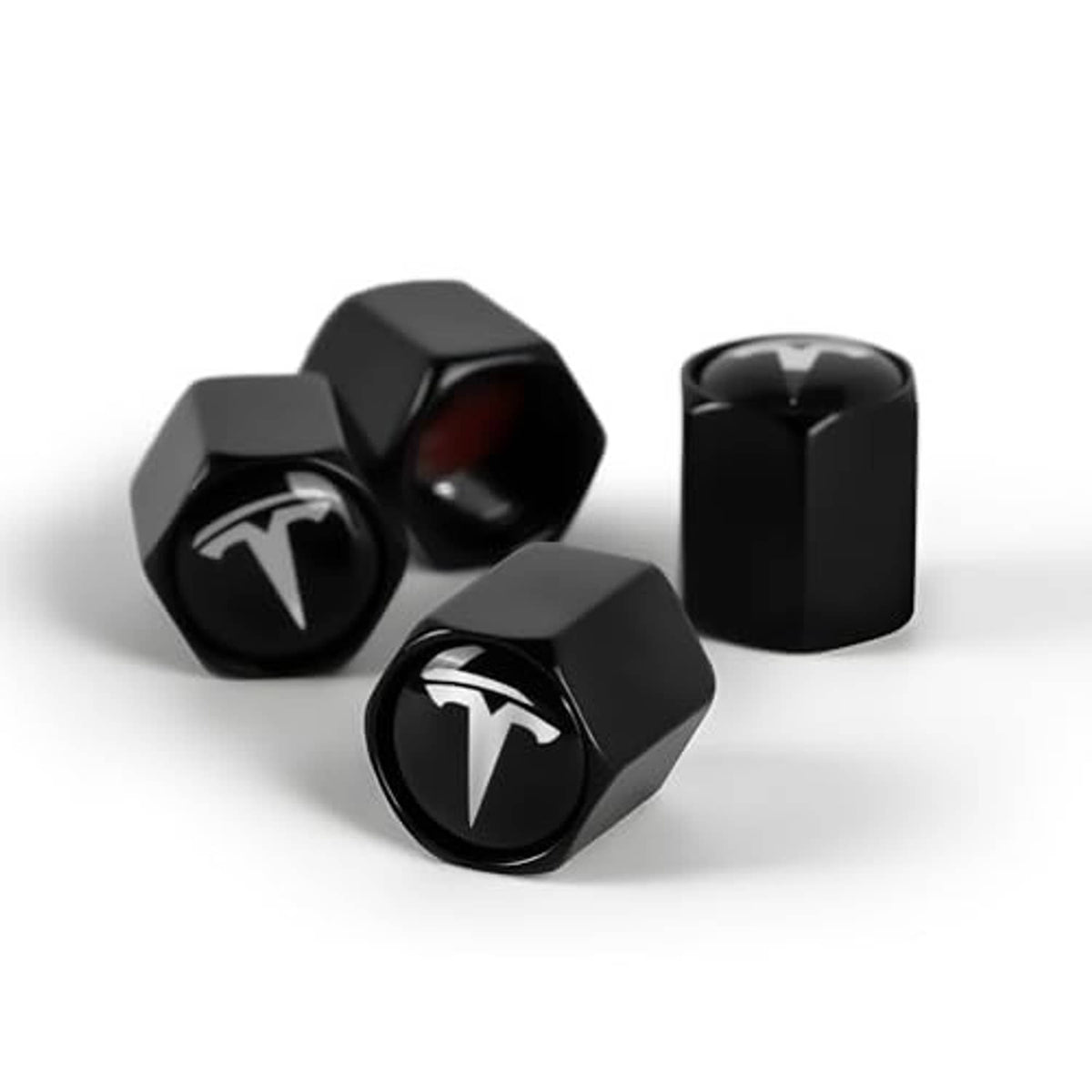 Black hex tire valve stem caps with Tesla logo, four-piece set with one upright