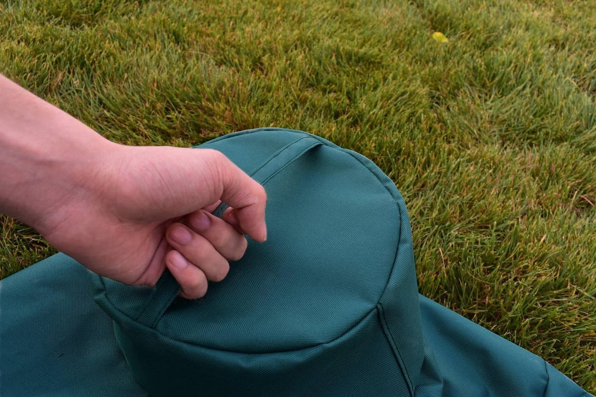 Mini grill cover hood detail in dark teal fabric, hand adjusting the top opening
