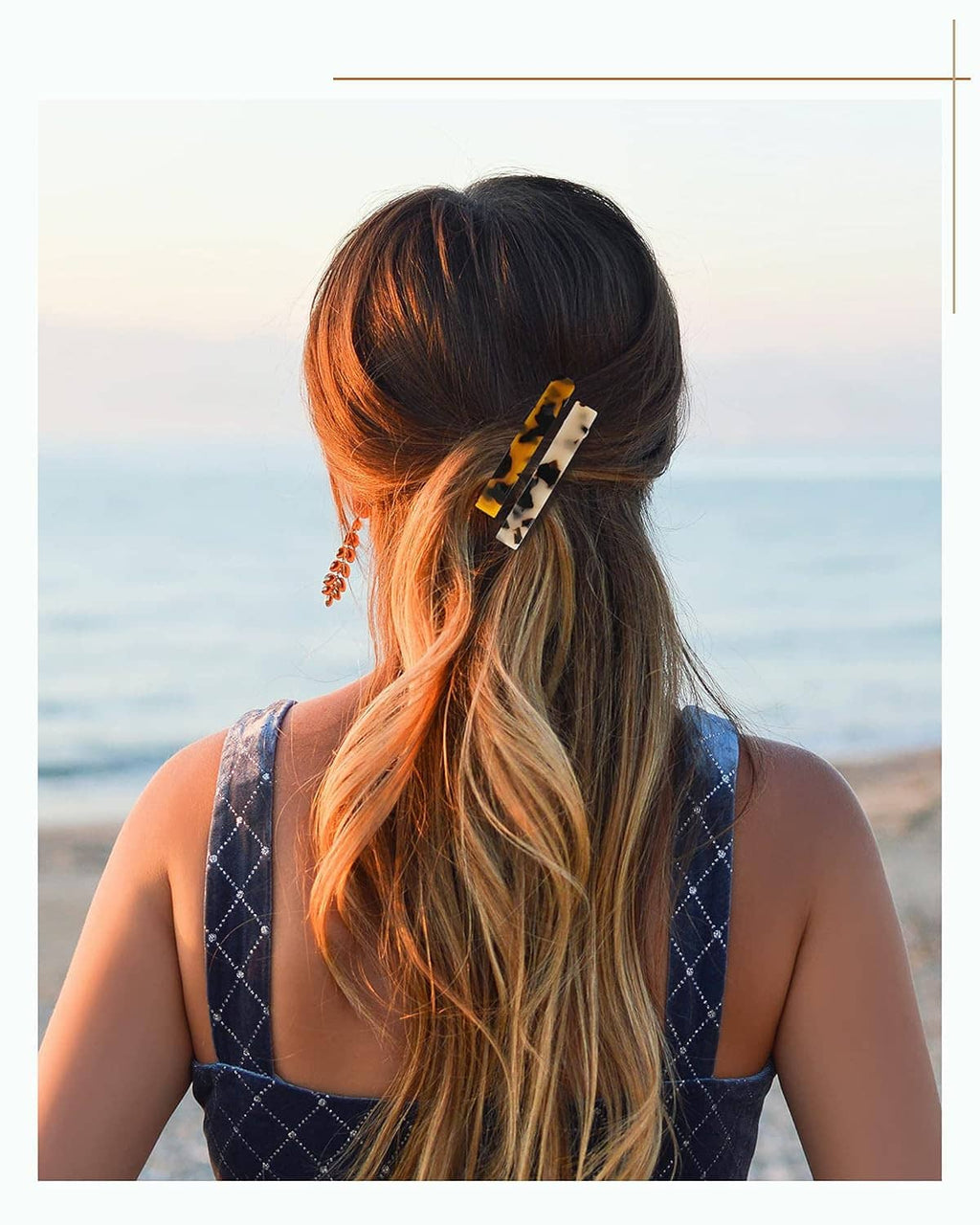 Tortoiseshell hair barrette clipped in place on a woman’s long hair from the back.