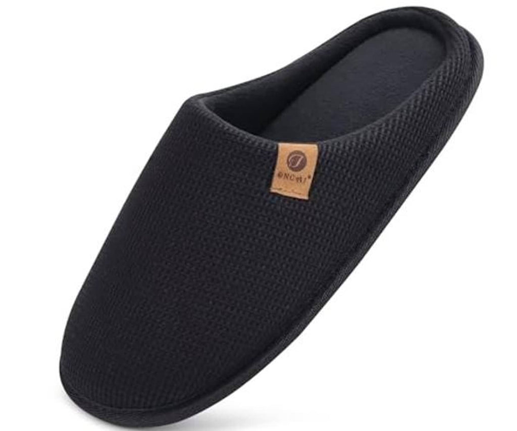 Black slip-on house slipper with waffle knit upper and soft fabric-lined opening.