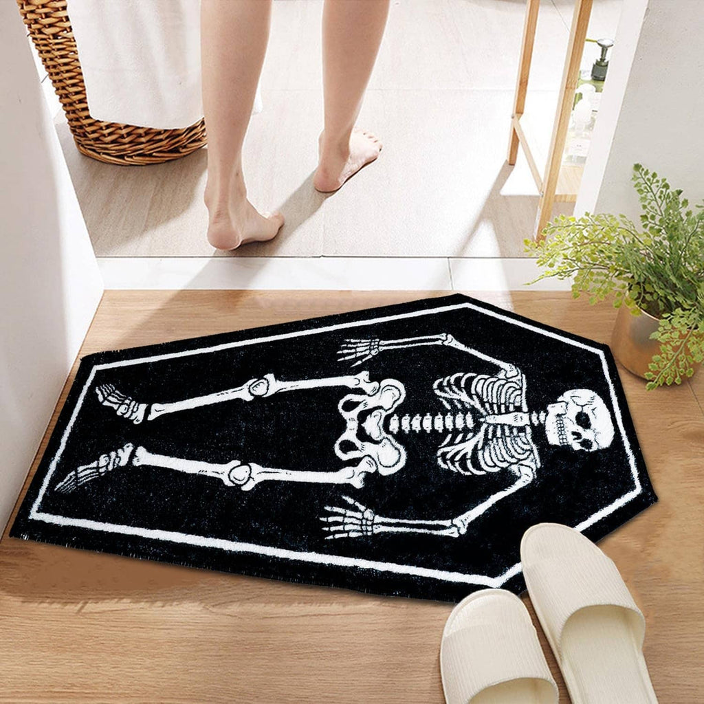 Rectangular black bath mat with white skeleton bones graphic, underfoot