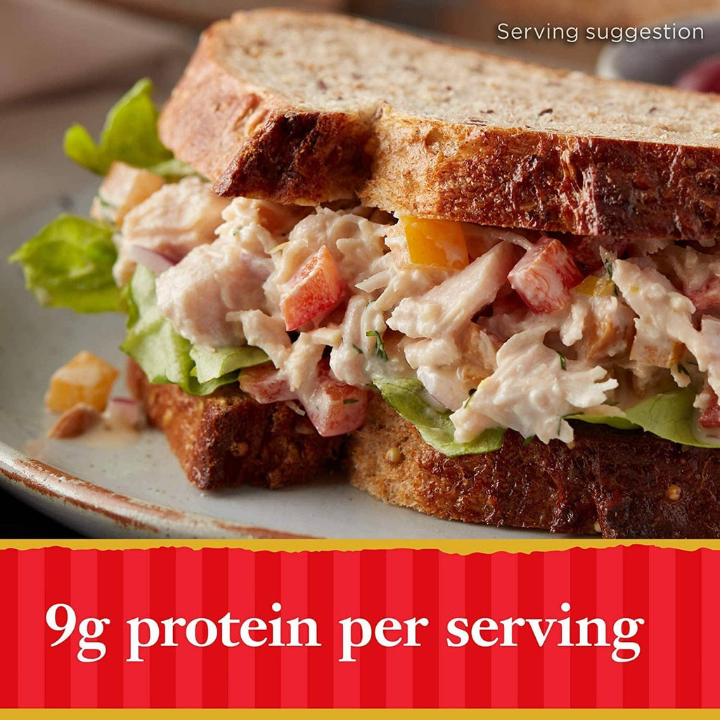 Sliced bread topped with shredded chicken and salad greens