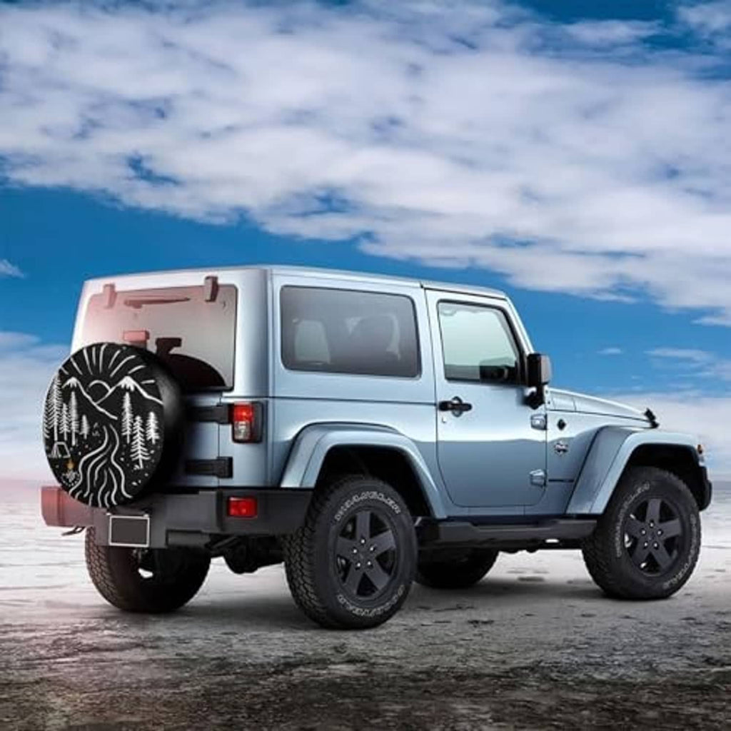 Spare tire cover on off-road vehicle, black with white forest and mountain artwork
