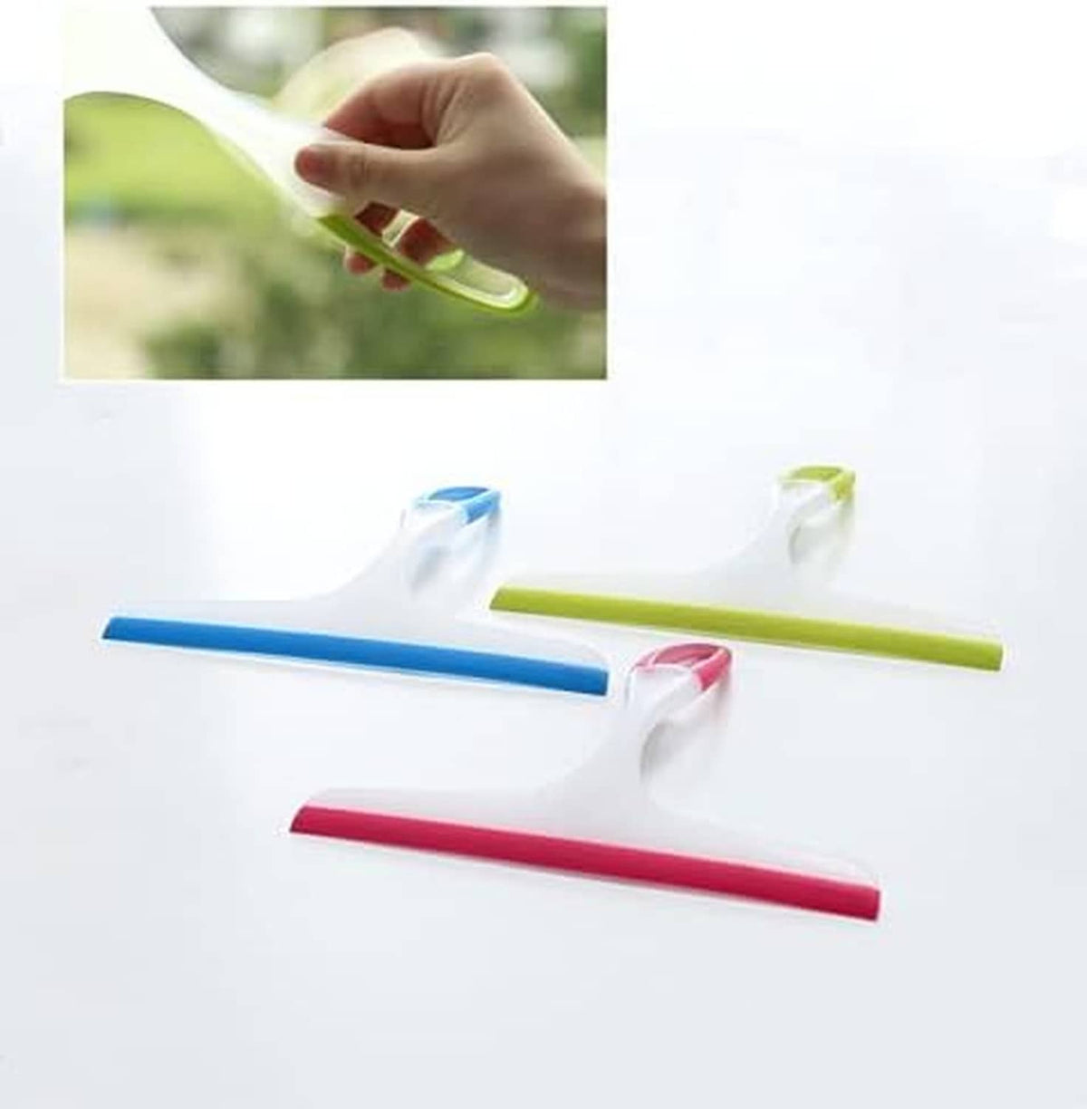 Three silicone shower squeegees with green, blue, and pink blades; hand holding green one.