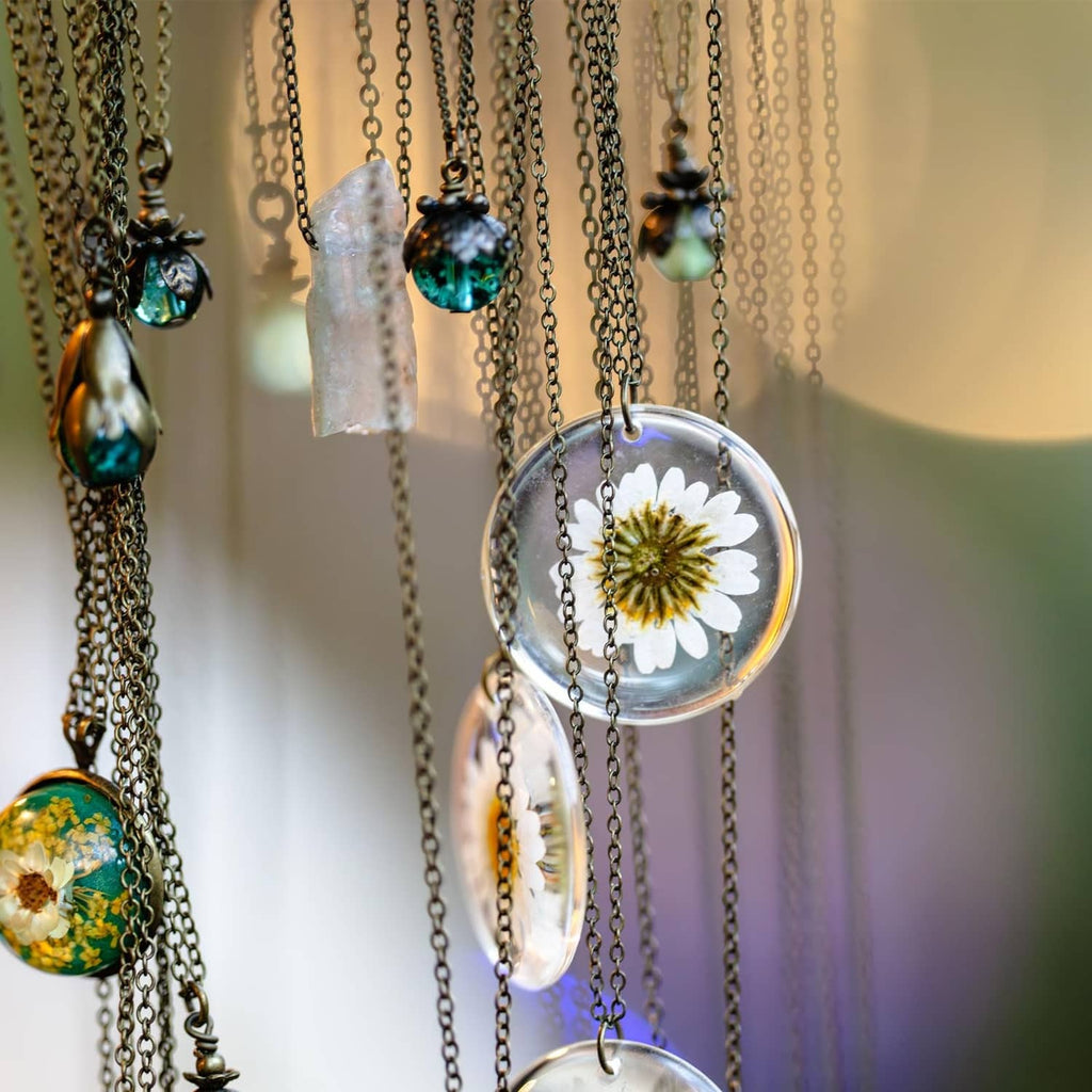 Silver-tone necklace with round domed crystal lens pendants and floral details