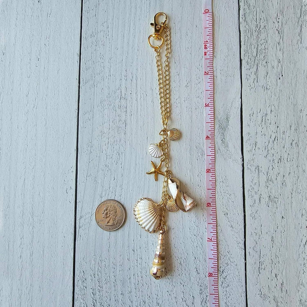 Gold hanging charm with seashells, starfish, and crystal beads on a chain