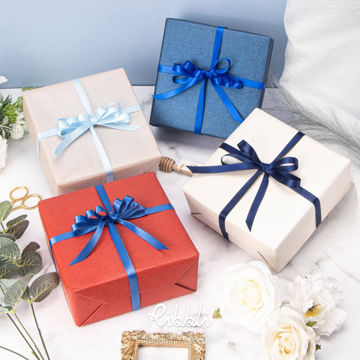 Blue satin ribbon bows on wrapped gift boxes with coordinated ribbon ties