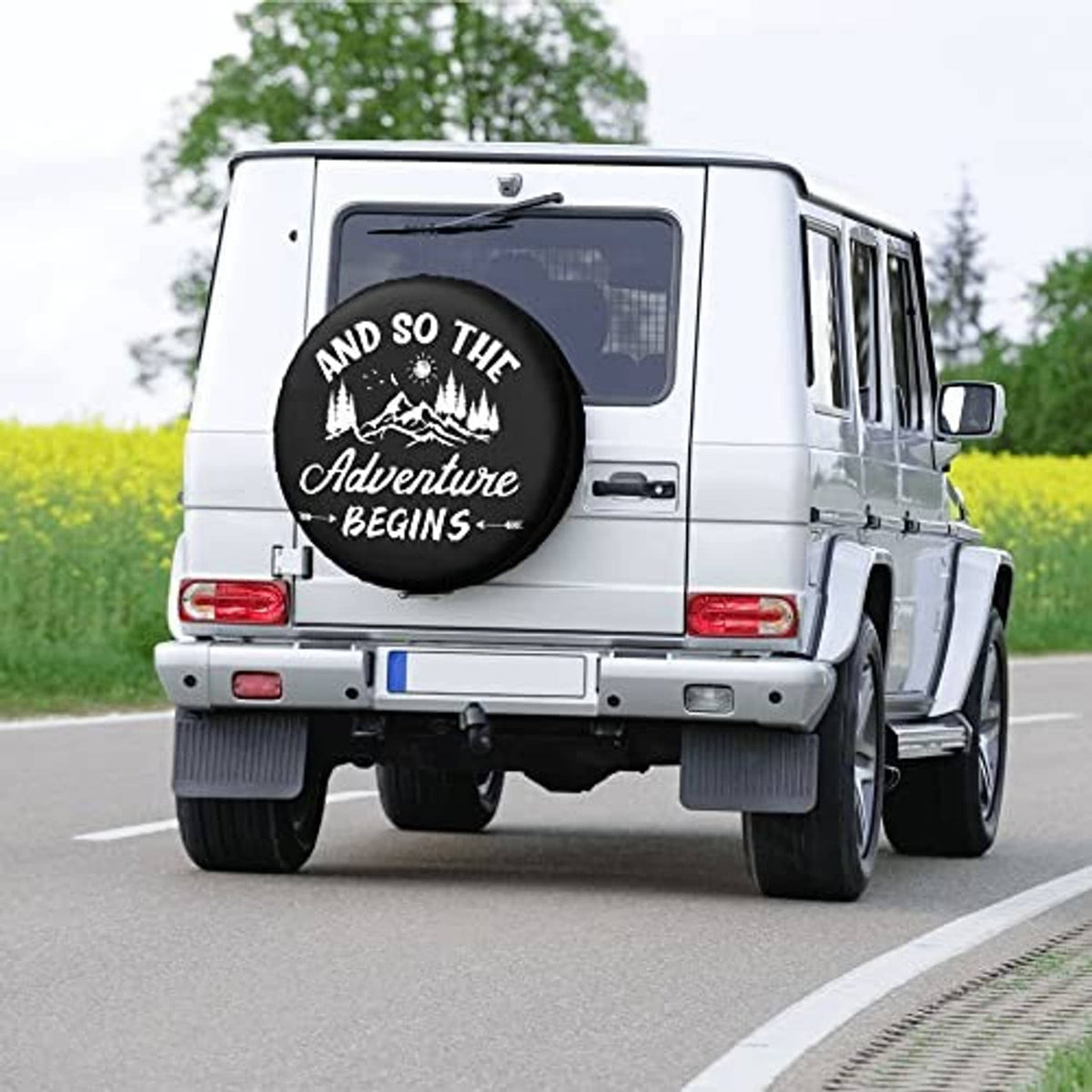 Black spare tire cover with “Adventure Begins” graphic on van rear door
