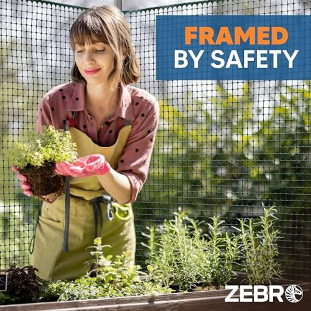Green square-mesh plastic garden fence with grid panel behind plants and shrubs