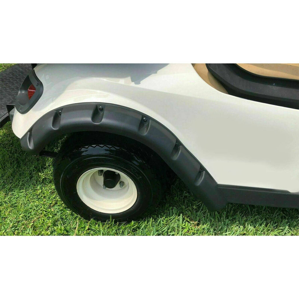 Black rear fender flare mounted on a white golf cart next to the wheel