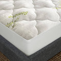 Queen mattress pad cover, white quilted top with green bamboo print, elastic skirt