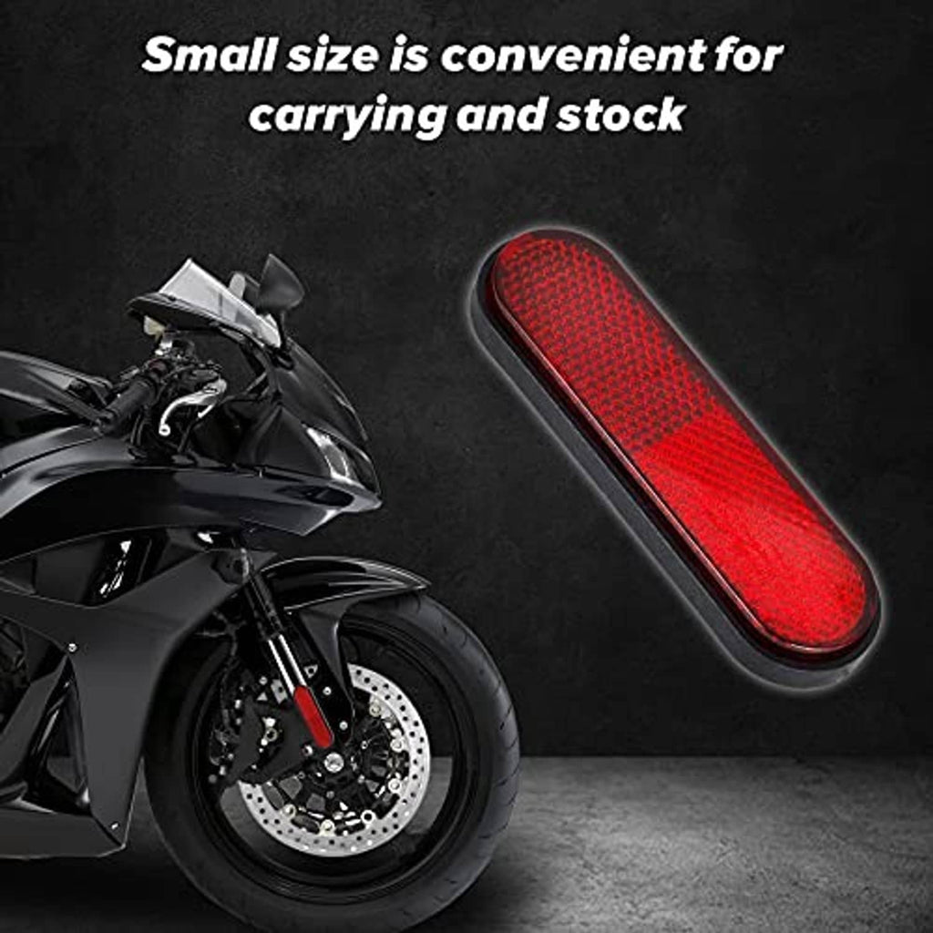 Red oval reflective motorcycle reflector sticker on black base, angled close-up