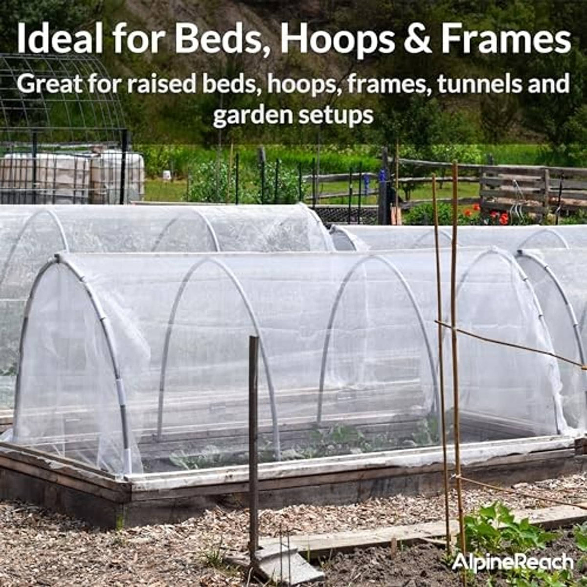 White mesh netting covers hoop-style greenhouse frames over planted rows