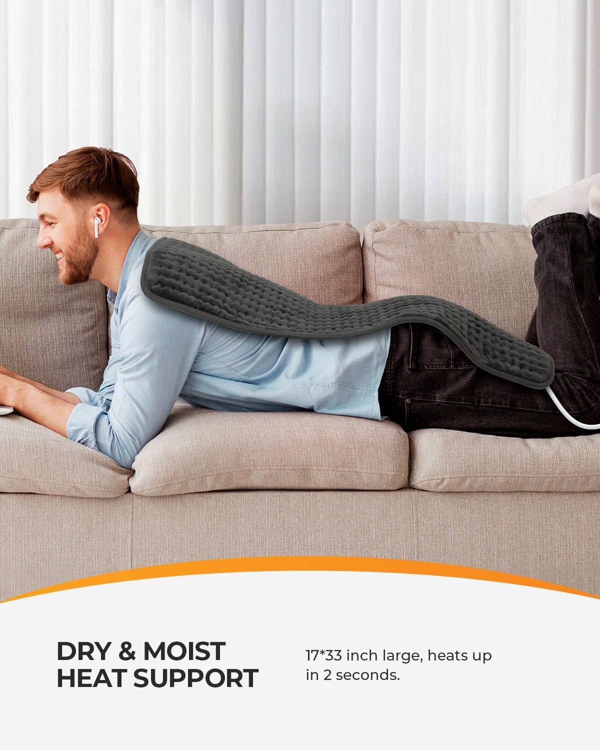 Gray electric heating pad draped over a man on a couch.