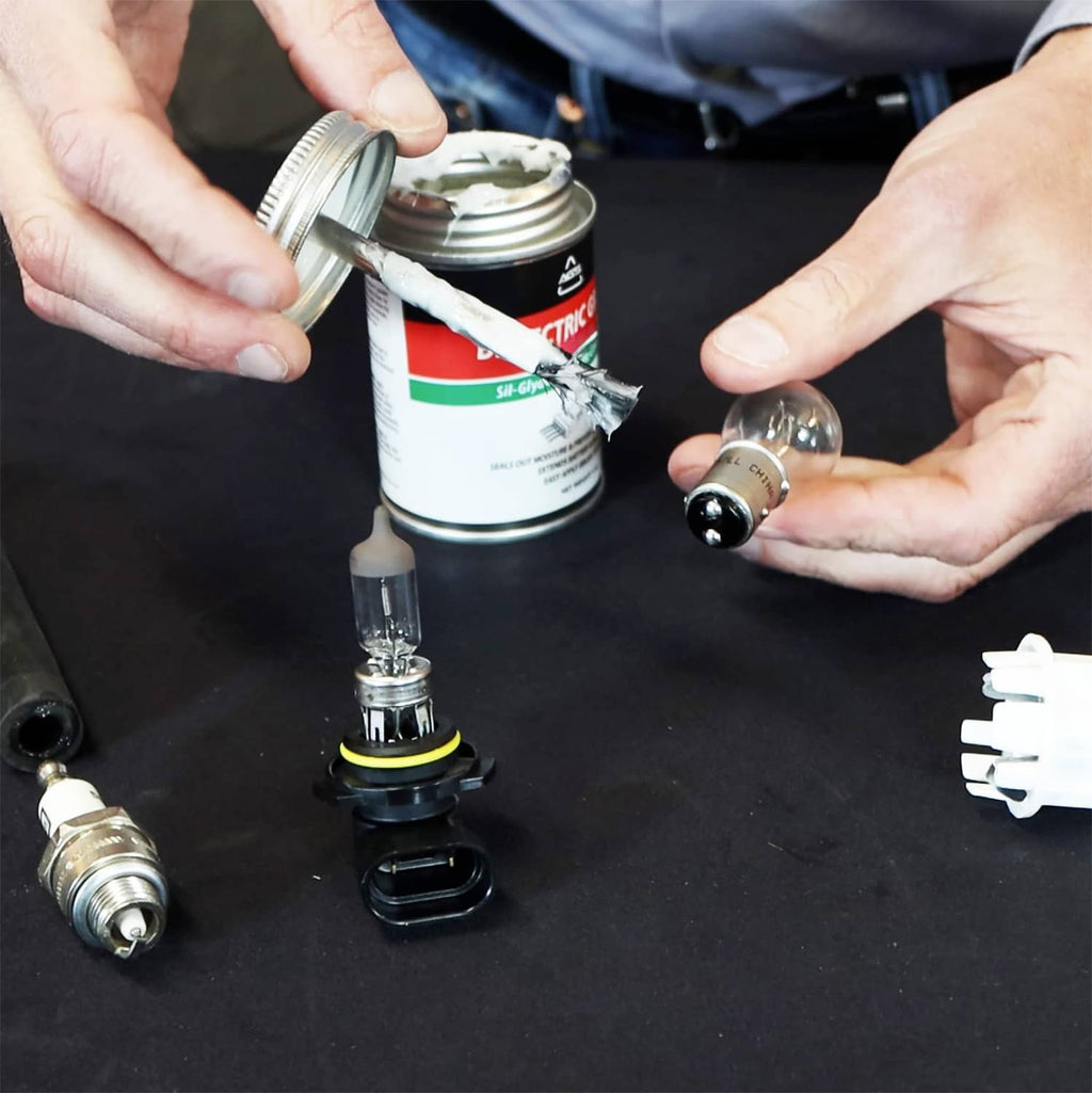 Dielectric grease can and brush applying silicone to electrical terminals