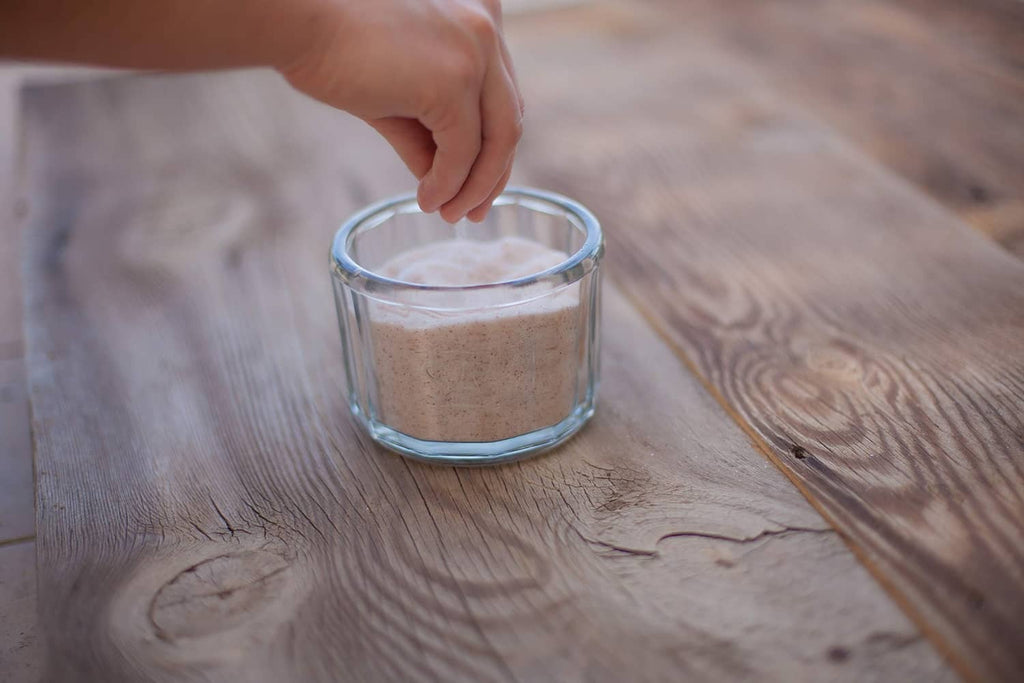 Fine sea salt in a small glass jar on a wooden table