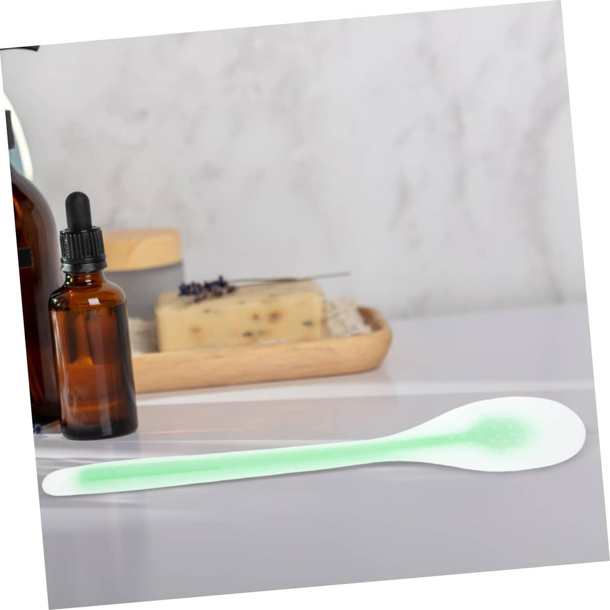 Green lotion applicator spoon with long handle and oval head for back application