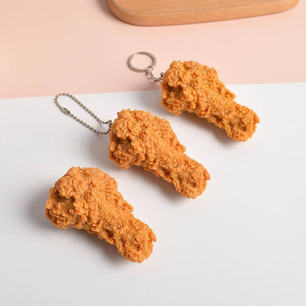 Three faux fried chicken drumsticks with metal chain and key ring, orange-brown.