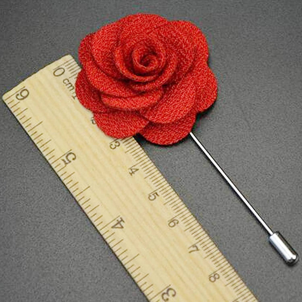 Red fabric rose lapel pin next to ruler for size reference