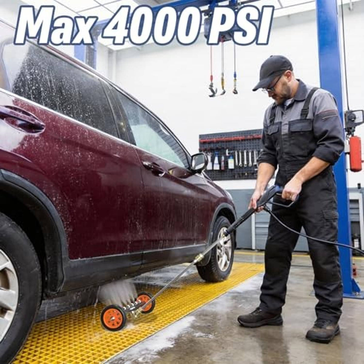 Technician using undercarriage pressure washer attachment to rinse vehicle wheel area