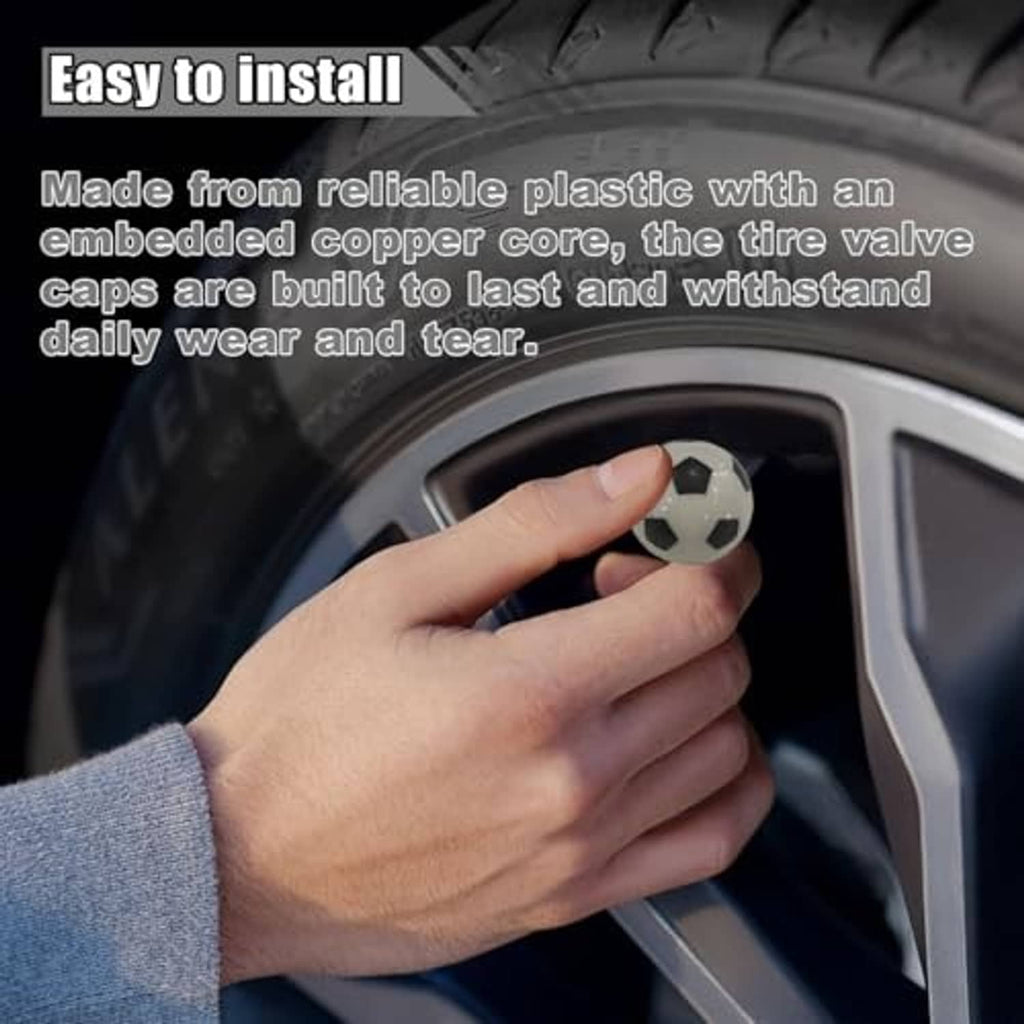 Hand installing a black-and-white soccer ball valve stem cap onto a car wheel valve.