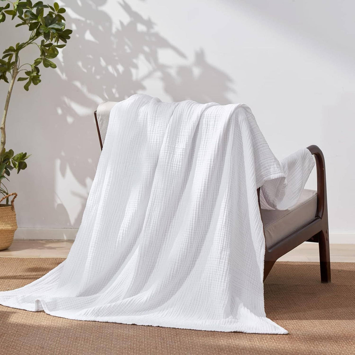 White muslin cotton throw blanket draped over a chair