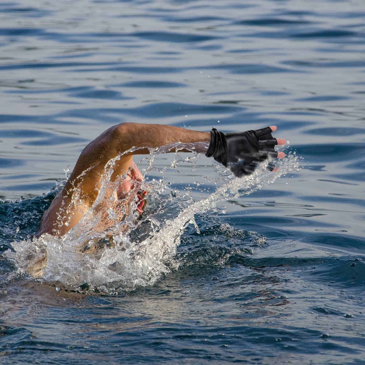 Black aquatic resistance gloves on swimmer hands above pool water