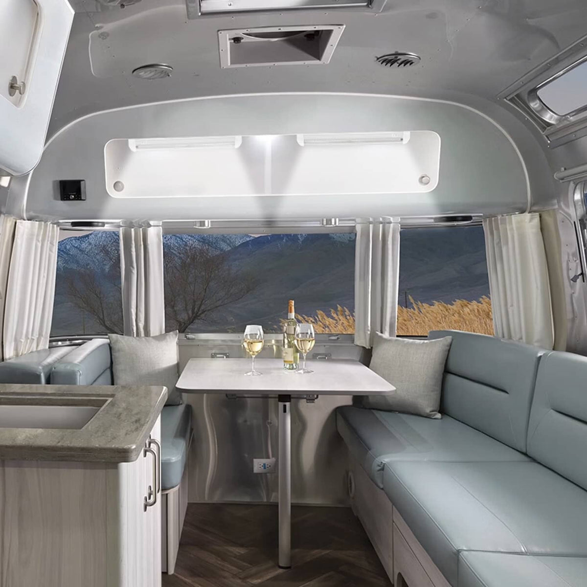 RV ceiling LED dome light fixture in white housing, mounted on trailer ceiling