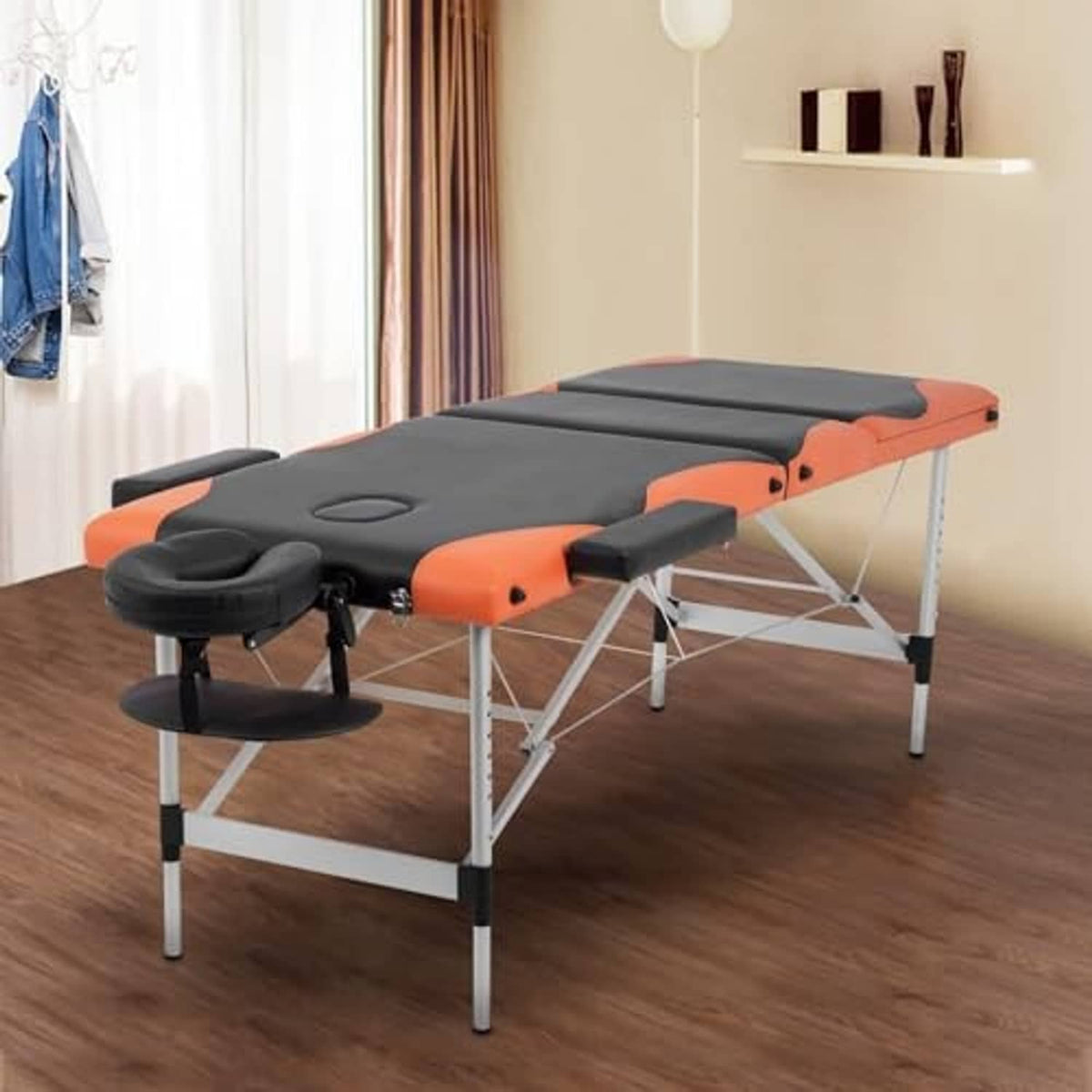 Orange and black adjustable massage table with padded headrest, arm support, and steel legs