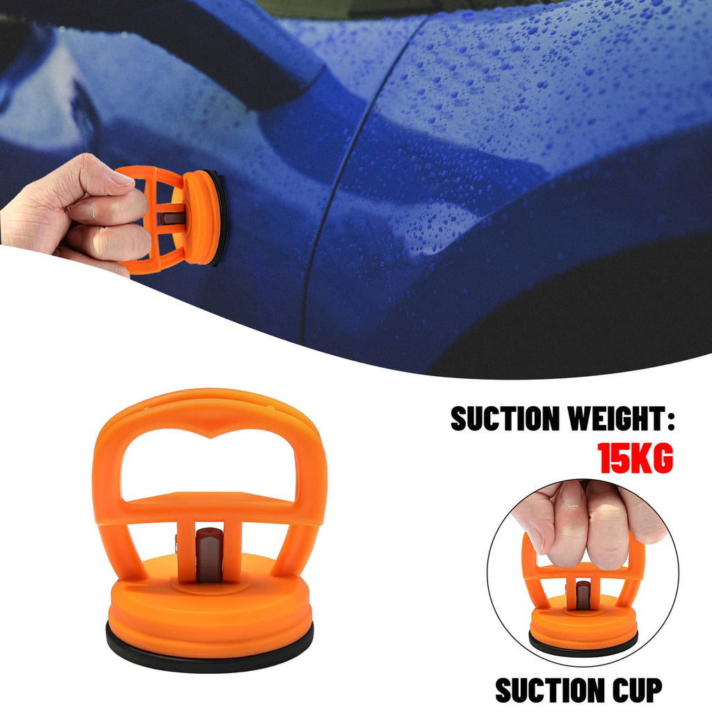 Orange suction cup dent puller tool pressed against a car panel by hand
