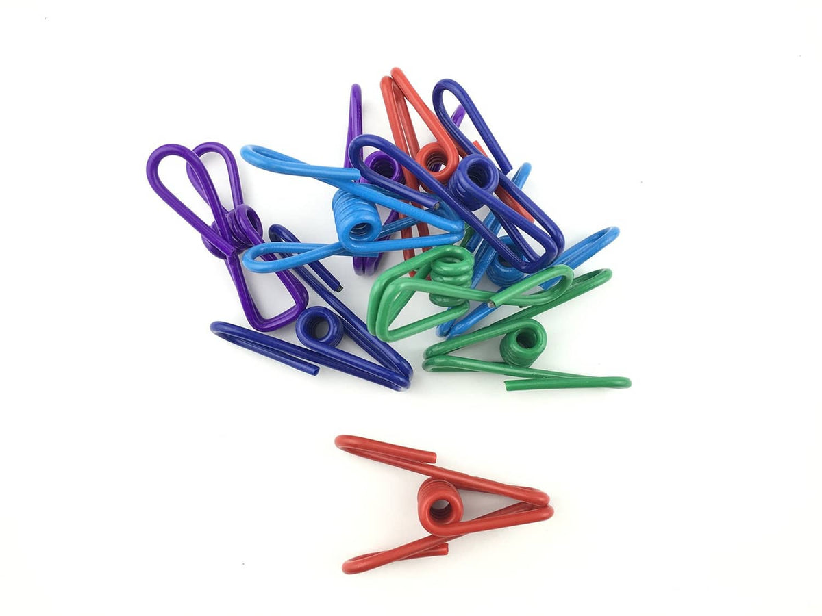 Assorted chip clips in purple, blue, green, and red, scattered in a pile