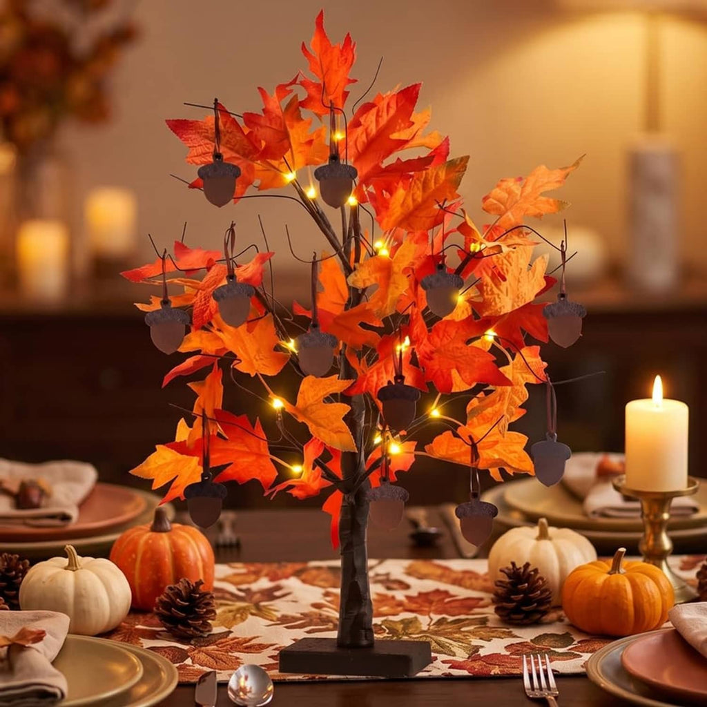 Orange maple leaf tree decoration with warm glowing LED bulbs and dangling acorn charms