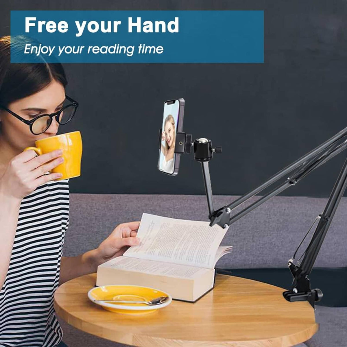 Black overhead tripod mount with clamp holding phone above open book