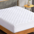 White quilted mattress pad topper covering the bed surface