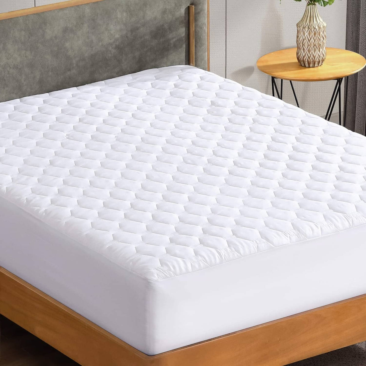 White quilted mattress pad topper covering the bed surface