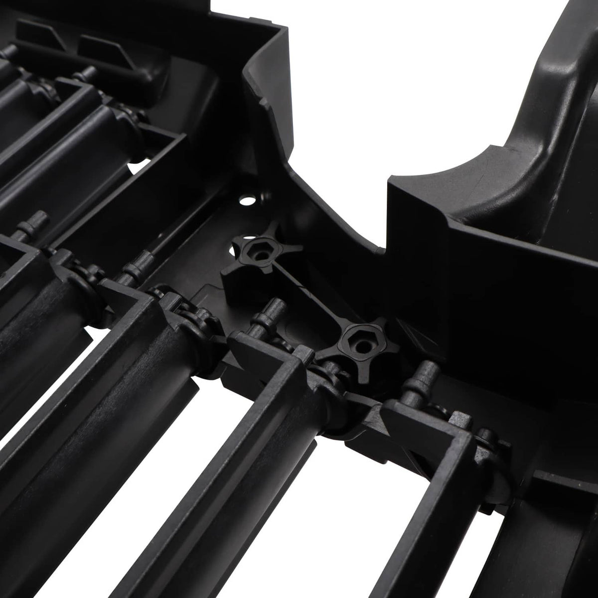 Close-up of black air shutter slats and linkage hardware inside the grille unit