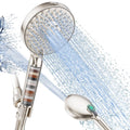 Brushed nickel handheld shower head with visible filter cartridge and water spray stream
