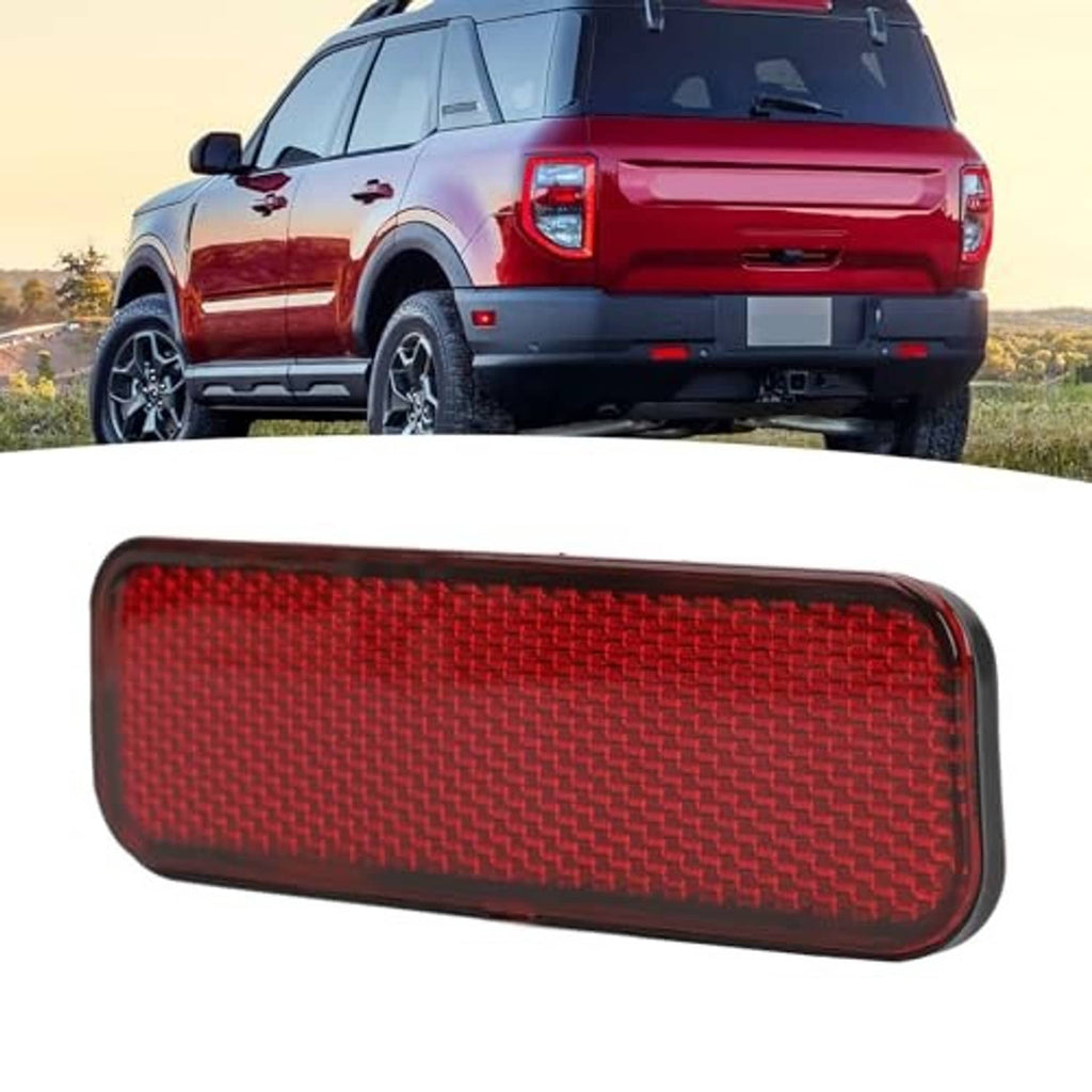 Red rectangular rear bumper reflector with textured lens and dark edging, front-angled
