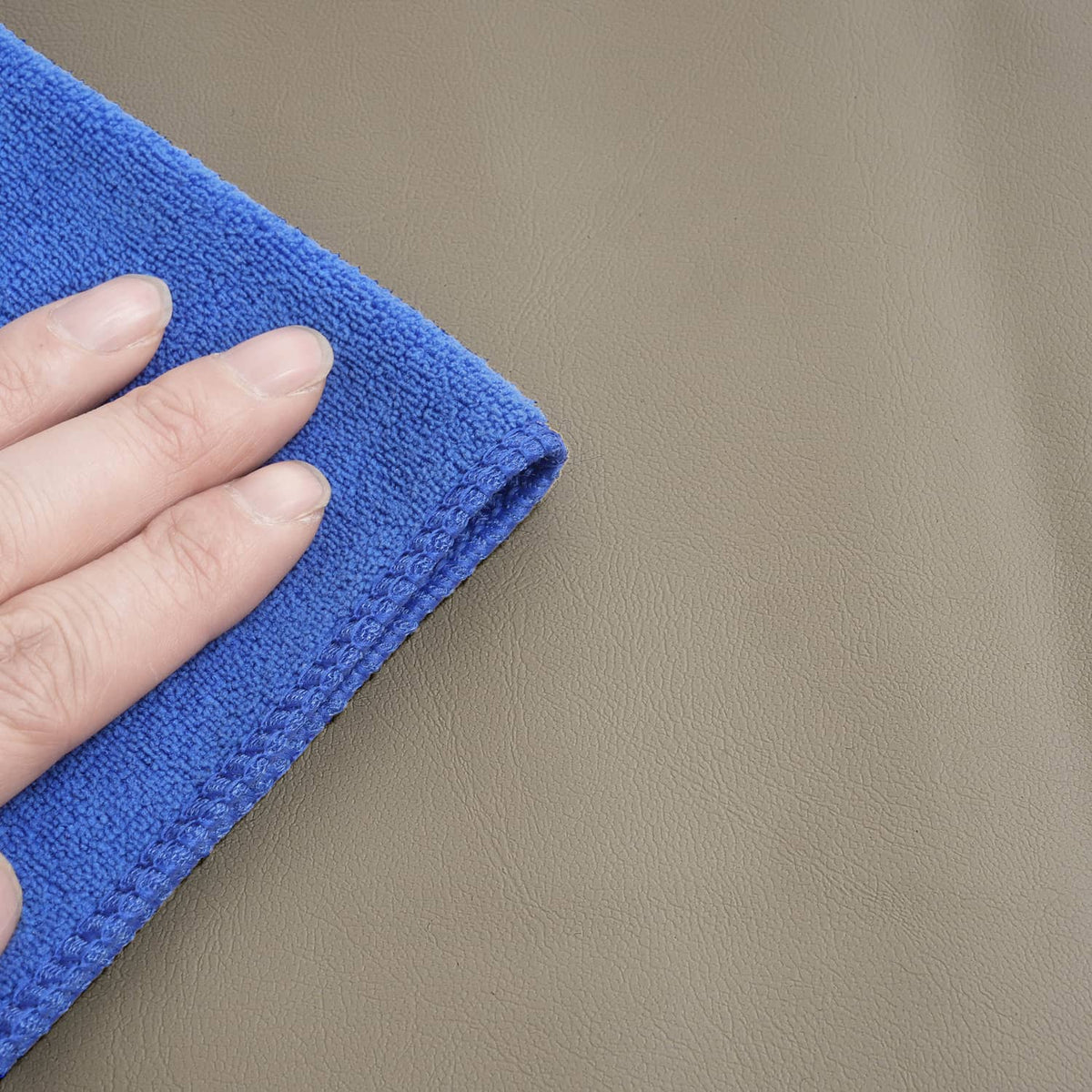 Tan seat cover fabric texture, with cloth wipe contact for surface cleaning.