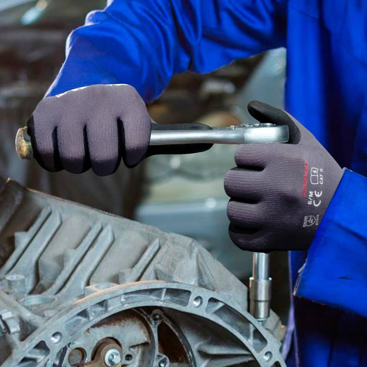 Worker wearing gray knit-and-black nitrile grip gloves using a metal tool